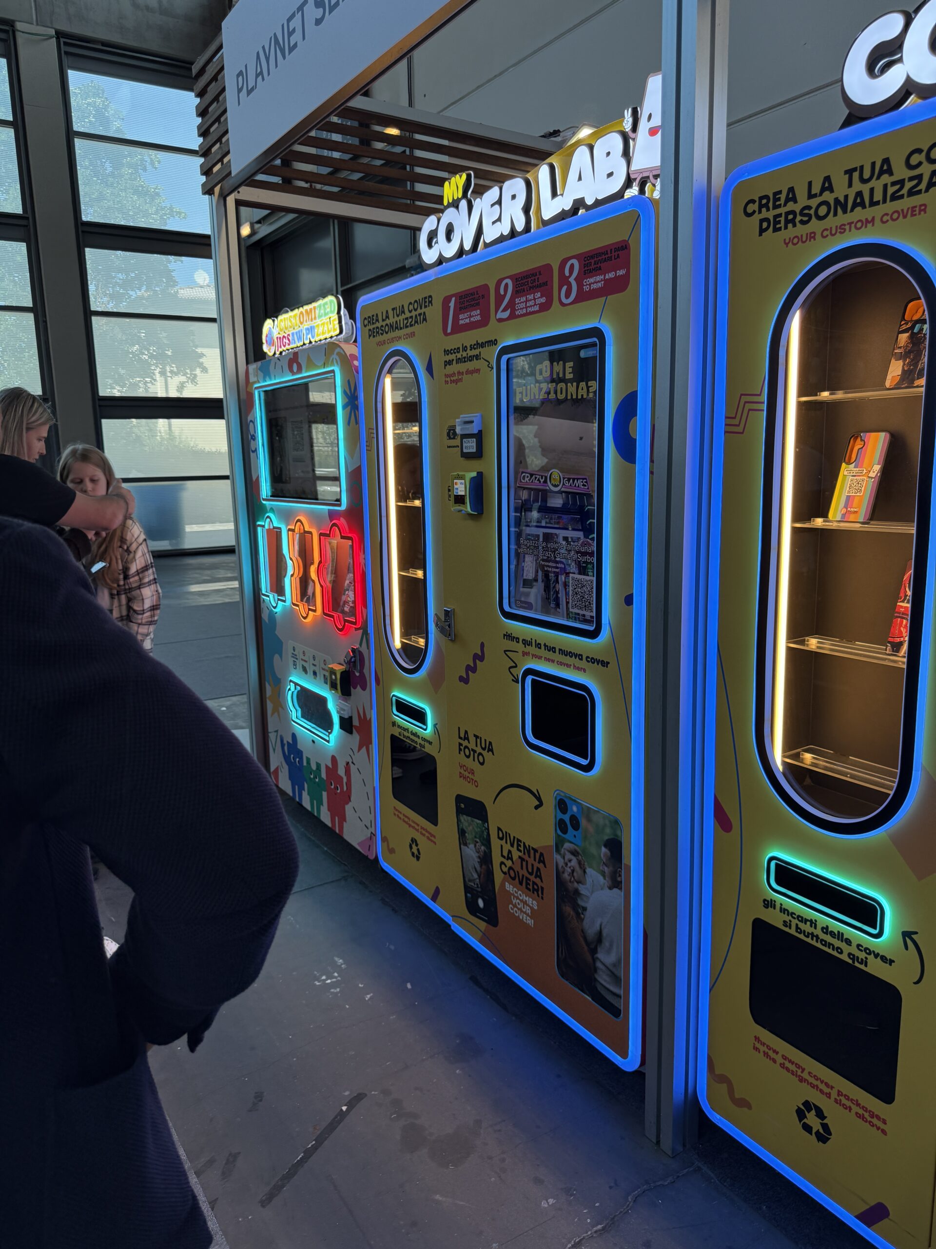 Bank of personalisation vending machines lit in a public venue